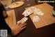 A person playing cards on a table with wine glasses.