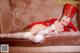 A woman in a red and white outfit laying on a couch.