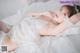 A woman in a white lingerie laying on a bed.