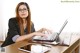 A woman sitting at a desk using a laptop computer.