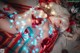 A woman in a red lingerie laying on a rug covered in lights.