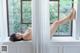 A naked woman laying on a window sill.