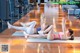 A couple of women doing stretching exercises in a gym.