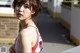 A woman in a red and white tank top posing for a picture.