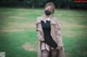 A woman wearing a face mask standing in a field.