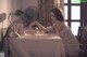 A woman sitting at a table with a bowl of food.